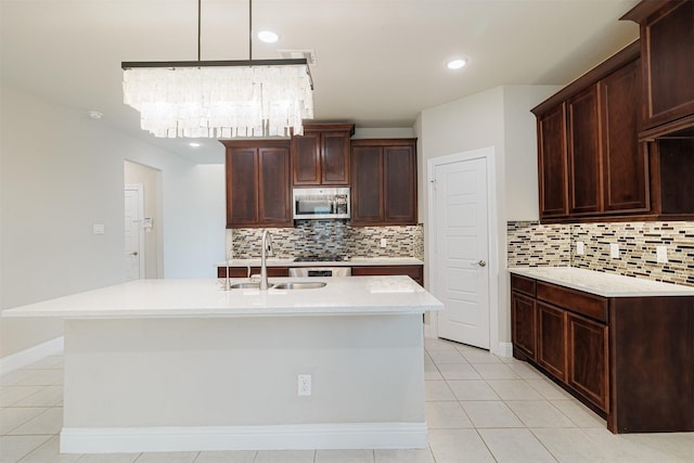 16719 Highland Country Dr, Cypress, TX 77433 - kitchen featuring stainless steel microwave, a sink, light countertops, decorative backsplash, and recessed lighting