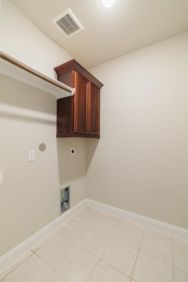 16719 Highland Country Dr, Cypress, TX 77433 - laundry area featuring hookup for an electric dryer, cabinet space, baseboards, and light tile patterned floors
