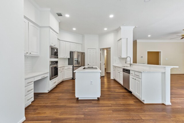 1327 Mission Chase Dr, Houston, TX 77077 - kitchen with appliances with stainless steel finishes, crown molding, a peninsula, tasteful backsplash, and recessed lighting