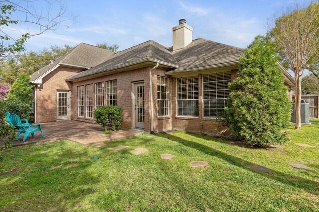 1327 Mission Chase Dr, Houston, TX 77077 - rear view of house with brick siding, roof with shingles, a patio area, a chimney, and a yard