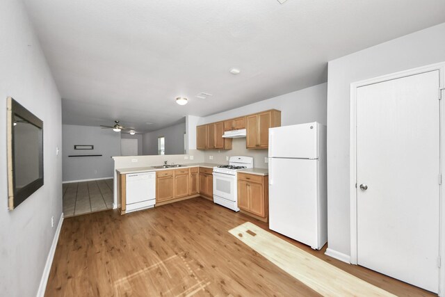 12047 Madison Oak St, Houston, TX 77038 - kitchen featuring white appliances, baseboards, light wood finished floors, a peninsula, and light countertops