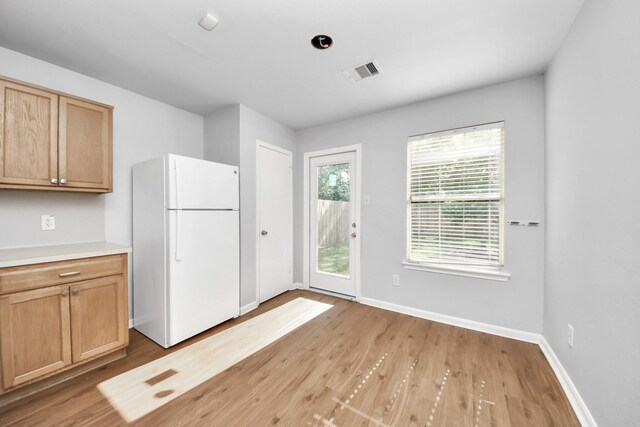 12047 Madison Oak St, Houston, TX 77038 - kitchen with freestanding refrigerator, light wood finished floors, baseboards, and light countertops