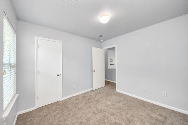 12047 Madison Oak St, Houston, TX 77038 - unfurnished bedroom featuring carpet flooring, multiple windows, and baseboards