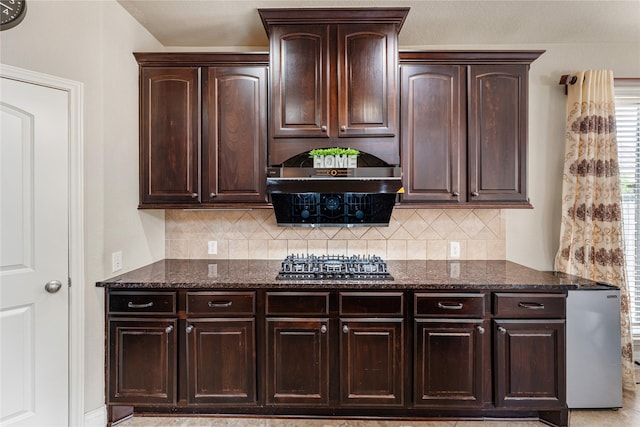 10827 Naburn Gate, Richmond, TX 77407 - kitchen with dark stone countertops, decorative backsplash, and dark brown cabinetry