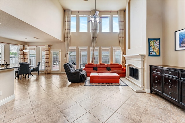 10827 Naburn Gate, Richmond, TX 77407 - living area featuring a premium fireplace, light tile patterned floors, a high ceiling, a ceiling fan, and baseboards