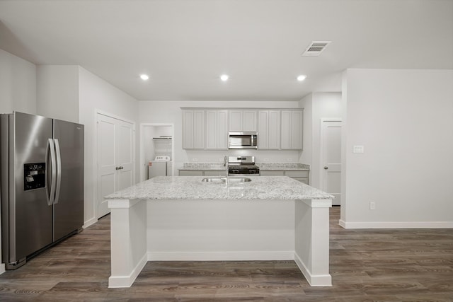752 Westpointe Dr, Dayton, TX 77535 - kitchen with appliances with stainless steel finishes, a kitchen island with sink, a sink, baseboards, and dark wood-style flooring
