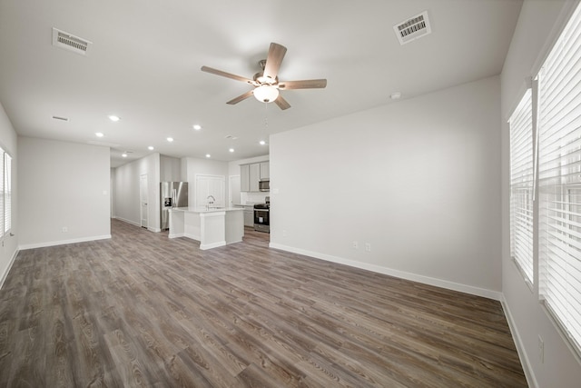 752 Westpointe Dr, Dayton, TX 77535 - unfurnished living room featuring a ceiling fan, dark wood-style flooring, baseboards, recessed lighting, and a sink