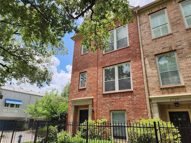2722 Crawford St, Houston, TX 77004 - view of property exterior with a fenced front yard and brick siding