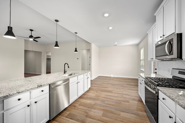 3029 Sorrento Hill Dr, Katy, TX 77493 - kitchen with appliances with stainless steel finishes, a ceiling fan, tasteful backsplash, light wood finished floors, and white cabinets