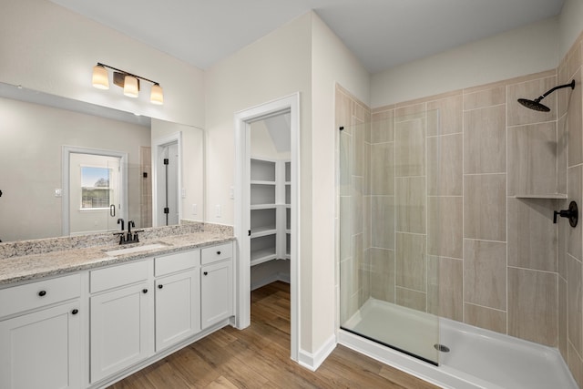 3029 Sorrento Hill Dr, Katy, TX 77493 - bathroom featuring a tile shower, vanity, wood finished floors, and a spacious closet