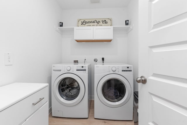 30114 Ousel Falls Ln, Fulshear, TX 77494 - laundry area featuring washing machine and clothes dryer, light wood finished floors, and cabinet space