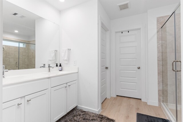30114 Ousel Falls Ln, Fulshear, TX 77494 - full bathroom with double vanity, a stall shower, wood finished floors, recessed lighting, and baseboards
