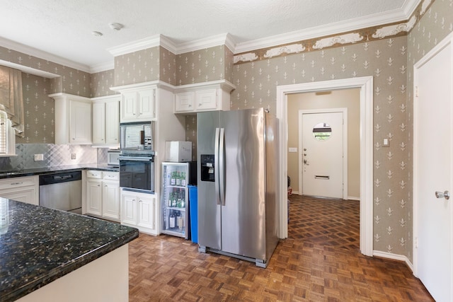 1403 N Thompson St, Conroe, TX 77301 - kitchen with stainless steel appliances, wallpapered walls, white cabinetry, tasteful backsplash, and dark stone counters