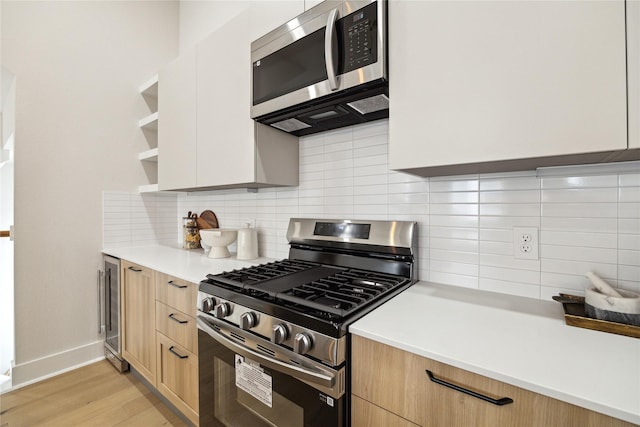 3907D Tulane St, Houston, TX 77018 - kitchen featuring stainless steel appliances, beverage cooler, light brown cabinetry, light countertops, and decorative backsplash