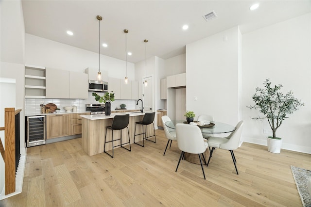 3907D Tulane St, Houston, TX 77018 - kitchen with stainless steel appliances, beverage cooler, light wood-type flooring, a sink, and decorative backsplash