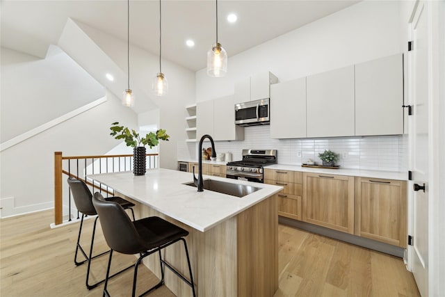 3907D Tulane St, Houston, TX 77018 - kitchen with stainless steel appliances, a sink, light wood finished floors, backsplash, and a kitchen bar