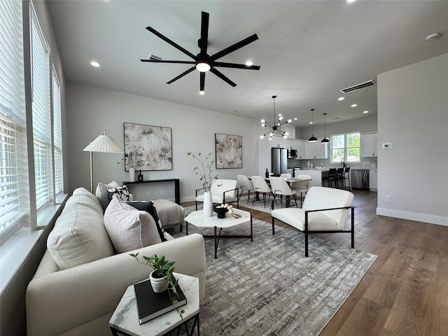 1803 Brooks St, Houston, TX 77026 - living area with dark wood-style flooring, recessed lighting, ceiling fan, baseboards, and a chandelier