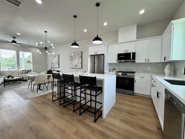 1803 Brooks St, Houston, TX 77026 - kitchen featuring stainless steel appliances, a sink, recessed lighting, a center island, and light wood-style flooring