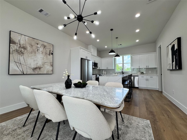 1803 Brooks St, Houston, TX 77026 - dining space with dark wood-style floors, baseboards, a chandelier, and recessed lighting