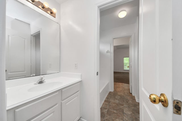 1605 Spring Glen Ln, Pearland, TX 77581 - bathroom with vanity, stone finish floors, baseboards, and a bath