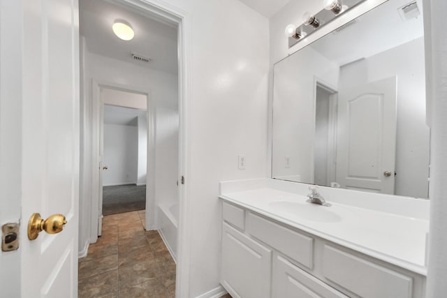 1605 Spring Glen Ln, Pearland, TX 77581 - bathroom with vanity, baseboards, stone finish floors, and a bath