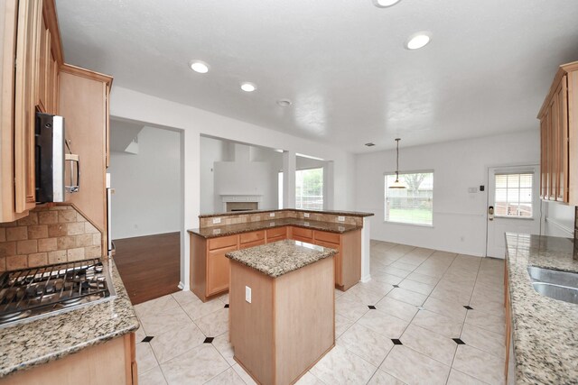 1605 Spring Glen Ln, Pearland, TX 77581 - kitchen with a kitchen island, stainless steel gas stovetop, healthy amount of natural light, light stone countertops, and recessed lighting