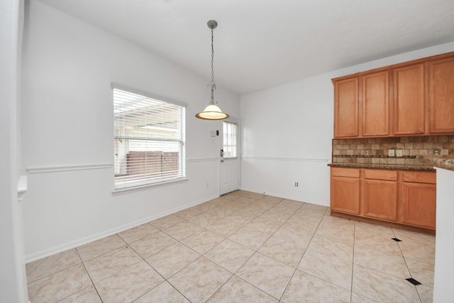1605 Spring Glen Ln, Pearland, TX 77581 - kitchen featuring tasteful backsplash, brown cabinetry, hanging light fixtures, and light tile patterned flooring