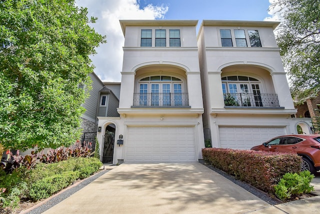 4220 Law St, Houston, TX 77005 - view of front of home featuring stucco siding, an attached garage, driveway, and a balcony