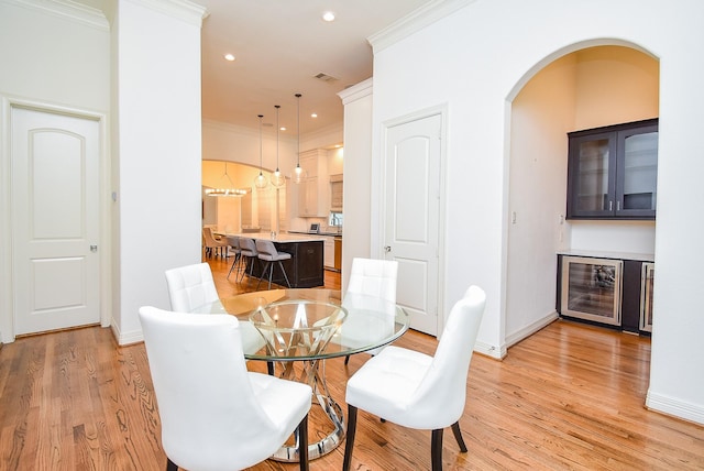 4220 Law St, Houston, TX 77005 - dining room featuring wine cooler, ornamental molding, light wood-style floors, baseboards, and recessed lighting