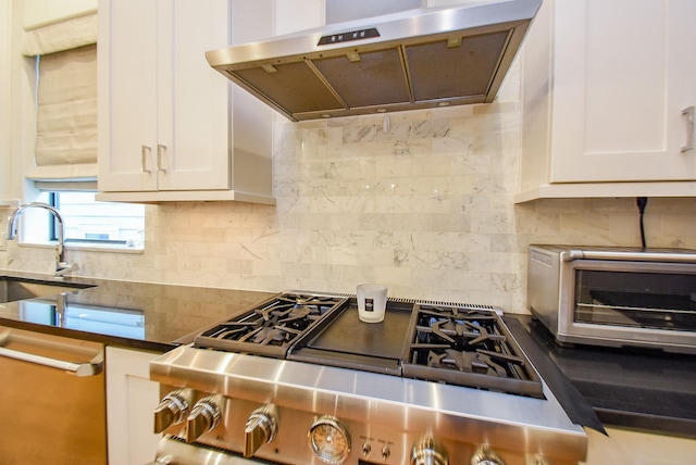 4220 Law St, Houston, TX 77005 - kitchen featuring under cabinet range hood, decorative backsplash, white cabinets, and dark countertops