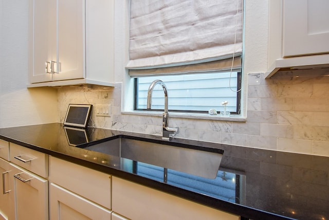 4220 Law St, Houston, TX 77005 - kitchen featuring a sink, dark countertops, backsplash, and white cabinetry