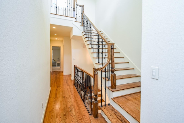 4220 Law St, Houston, TX 77005 - staircase featuring a towering ceiling, wood finished floors, baseboards, a textured wall, and recessed lighting