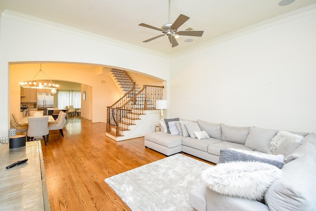 4220 Law St, Houston, TX 77005 - living room featuring arched walkways, stairs, ceiling fan, light wood-style floors, and crown molding