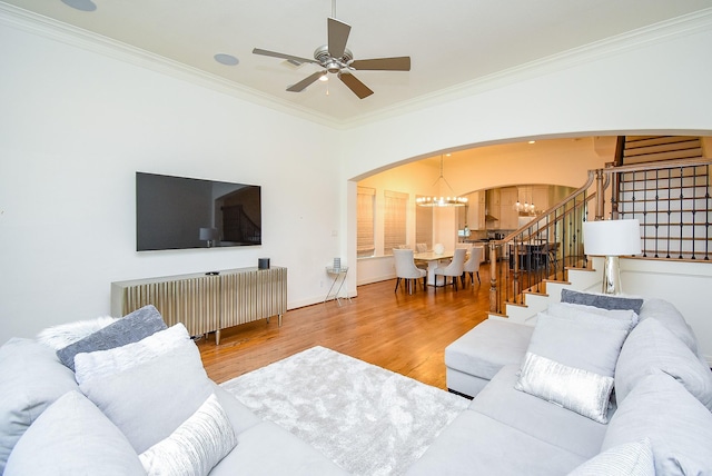 4220 Law St, Houston, TX 77005 - living area with arched walkways, a chandelier, wood finished floors, ornamental molding, and stairs