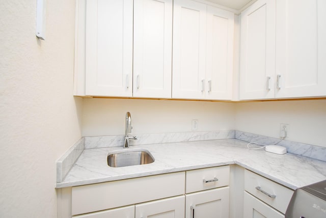 4220 Law St, Houston, TX 77005 - kitchen featuring a sink, white cabinetry, and light stone countertops