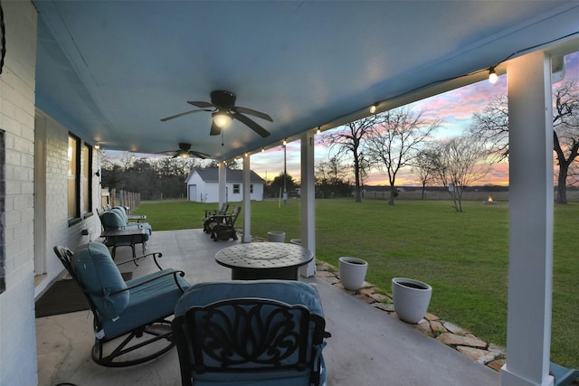 4620 Springfield Ln, Brenham, TX 77833 - patio terrace at dusk with a yard, a ceiling fan, an outbuilding, and a patio
