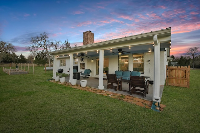 4620 Springfield Ln, Brenham, TX 77833 - back of house at dusk featuring a chimney, ceiling fan, a patio, and outdoor lounge area