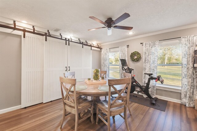 4620 Springfield Ln, Brenham, TX 77833 - dining room with a barn door, baseboards, wood finished floors, a ceiling fan, and ornamental molding