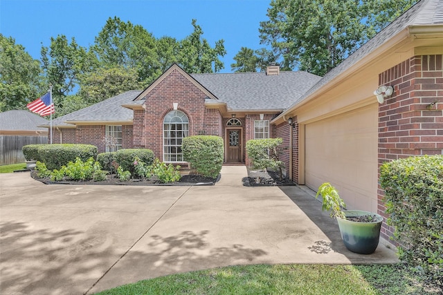 529 Stephen F Austin Dr, Conroe, TX 77302 - view of front facade with brick siding, roof with shingles, a garage, a chimney, and concrete driveway