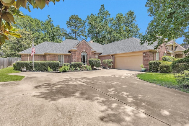 529 Stephen F Austin Dr, Conroe, TX 77302 - view of front facade featuring brick siding, roof with shingles, and concrete driveway