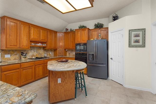 529 Stephen F Austin Dr, Conroe, TX 77302 - kitchen with black appliances, lofted ceiling, tasteful backsplash, brown cabinets, and a breakfast bar area