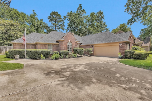 529 Stephen F Austin Dr, Conroe, TX 77302 - view of front of home featuring brick siding, a shingled roof, an attached garage, and concrete driveway