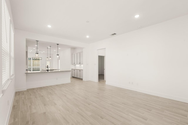 17051 Lilac Paxton Ln, Hockley, TX 77447 - unfurnished living room with a sink, light wood-style flooring, recessed lighting, and baseboards