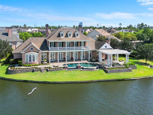 31 Southern Crescent Ct, The Woodlands, TX 77380 - rear view of house with a balcony, a chimney, an outdoor pool, and a yard
