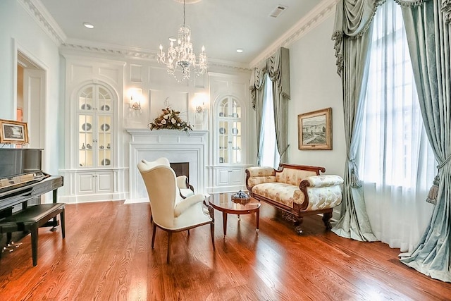 31 Southern Crescent Ct, The Woodlands, TX 77380 - living area featuring wood finished floors, plenty of natural light, a chandelier, crown molding, and a fireplace