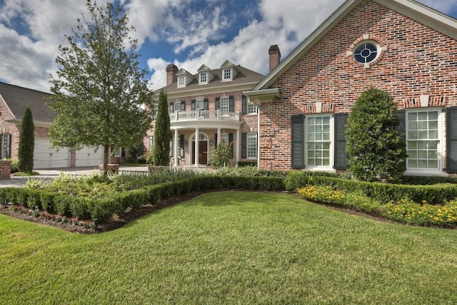 31 Southern Crescent Ct, The Woodlands, TX 77380 - colonial home featuring brick siding, a chimney, a front lawn, and a balcony
