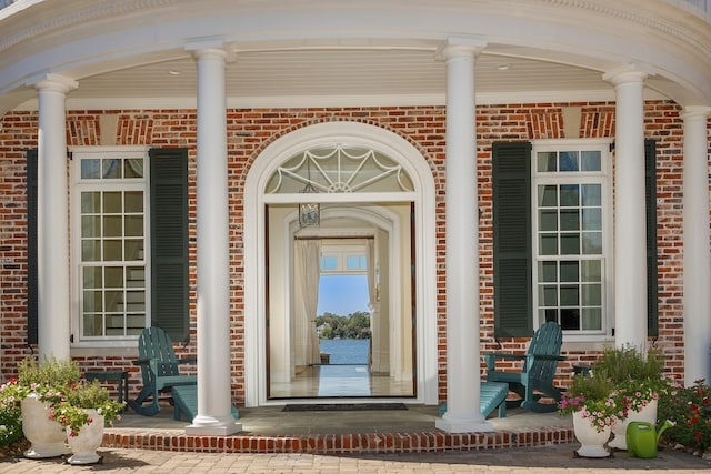 31 Southern Crescent Ct, The Woodlands, TX 77380 - doorway to property featuring a porch and brick siding
