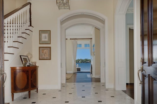 31 Southern Crescent Ct, The Woodlands, TX 77380 - foyer entrance featuring arched walkways, baseboards, ornamental molding, marble finish floors, and stairs