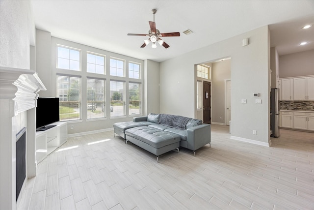 9650 Caddo Ridge Ln, Cypress, TX 77433 - living room featuring ceiling fan, baseboards, a fireplace, light wood-style flooring, and recessed lighting