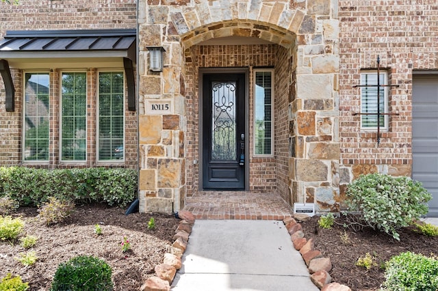 10115 Cypress Path, Missouri City, TX 77459 - view of exterior entry featuring stone siding, a standing seam roof, and brick siding